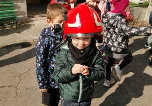 Chłopiec przymierza hełm strażacki
