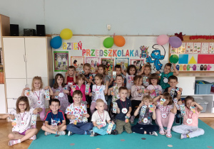 Dzieci pozują z upominkami w dniu swojego święta.