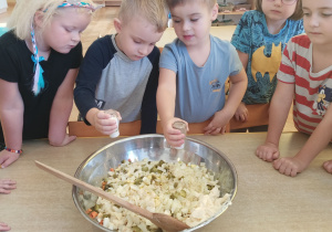 Chłopcy sypią sól i pieprz do sałatki.