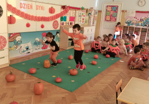 Dwóch chłopców przeskakuje przez dynie.