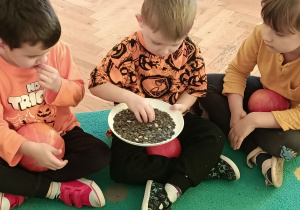 Chłopcy jedzą suszone pestki dyni.