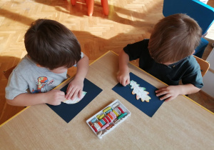 chłopcy odrysowują liście