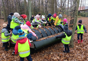 Dzieci wchodzą na walec śniegowy.