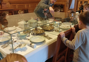 Dzieci oglądają zastawę stołową.