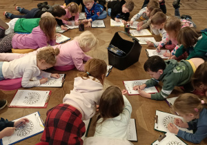 Dzieci kolorują pawia.