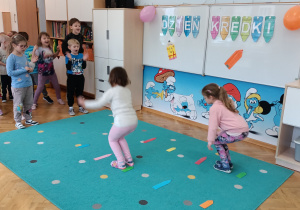 Dziewczynki skaczą przez kredki.