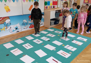 Chłopiec z dziewczynką idą pozakodowanym dywanie.