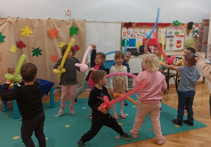 Dzieci bawią się balonowymi mieczami.