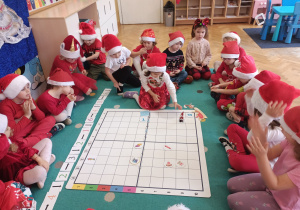 Dziewczynka prowadzi Mikołaja po macie do kodowania.