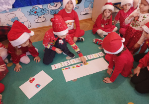 Chłopiec układa prezenty wg kolejności cyfr.