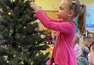 dziewczynka ubiera choinkę