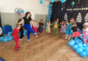 Dzieci naśladują ruchy za animatorką.