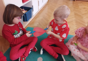 Dziewczynka podaje serduszko chłopcu za pomocą klamerki.