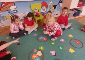 Dziewczynka segreguje serduszka oznaczone cyframi.