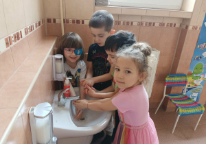 Dzieci spłukują mydło.