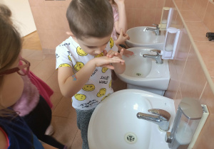 Chłopiec wącha pachnące dłonie.