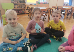 Dzieci pokazują maskotkę kropelkę.