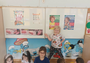 Dziewczynka pokazuje kolejność czynności podczas mycia rąk.