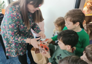 Pani wręcza dzieciom upominki.