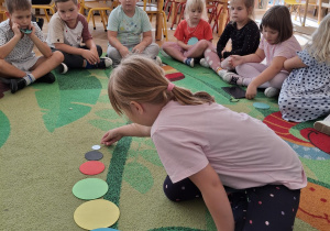 Dziewczynka układa kropki według wielkości