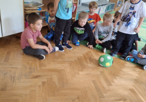 Chłopiec kopie piłkę do bramki