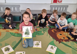 Chłopiec pokazuje drzewo iglaste