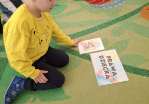 Chłopiec kładzie ilustację przedstawiającą jedno z praw dziecka