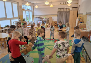 Dzieci bawią się w kole z misiami