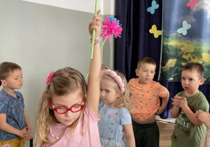 2 dziewczynki tańczą z kwiatkami.