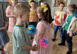 Dziewczynka tańczy z chłopcem.