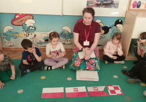 Dzieci obserwują różne flagi Polski.