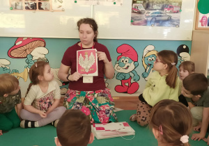 Dzieci oglądaja zdjęcie godła Polski.