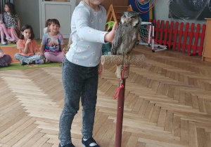 Dziewczynka głaszcze sowę.