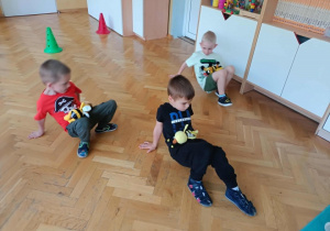 Chłopcy przenoszą pszczoły - maskotki na brzuchu.