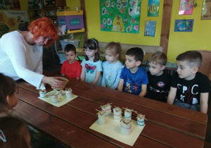 Pani leje wosk do formy, z której powstanie świeczka.