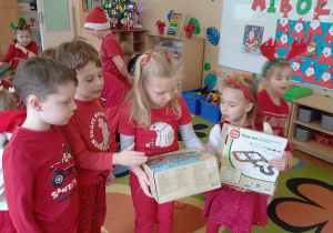 Dzieci oglądają rozpakowane prezenty