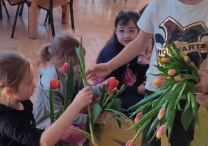 Chłopiec wręcza tulipana dziewczynce.
