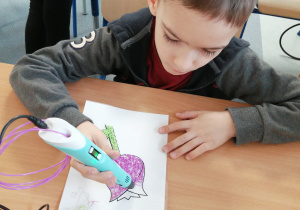 Chłopiec rysuje kwiatek długopisem 3D