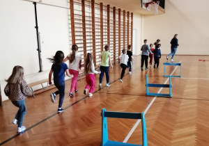 Dzieci biegną dookoła sali gimnastycznej